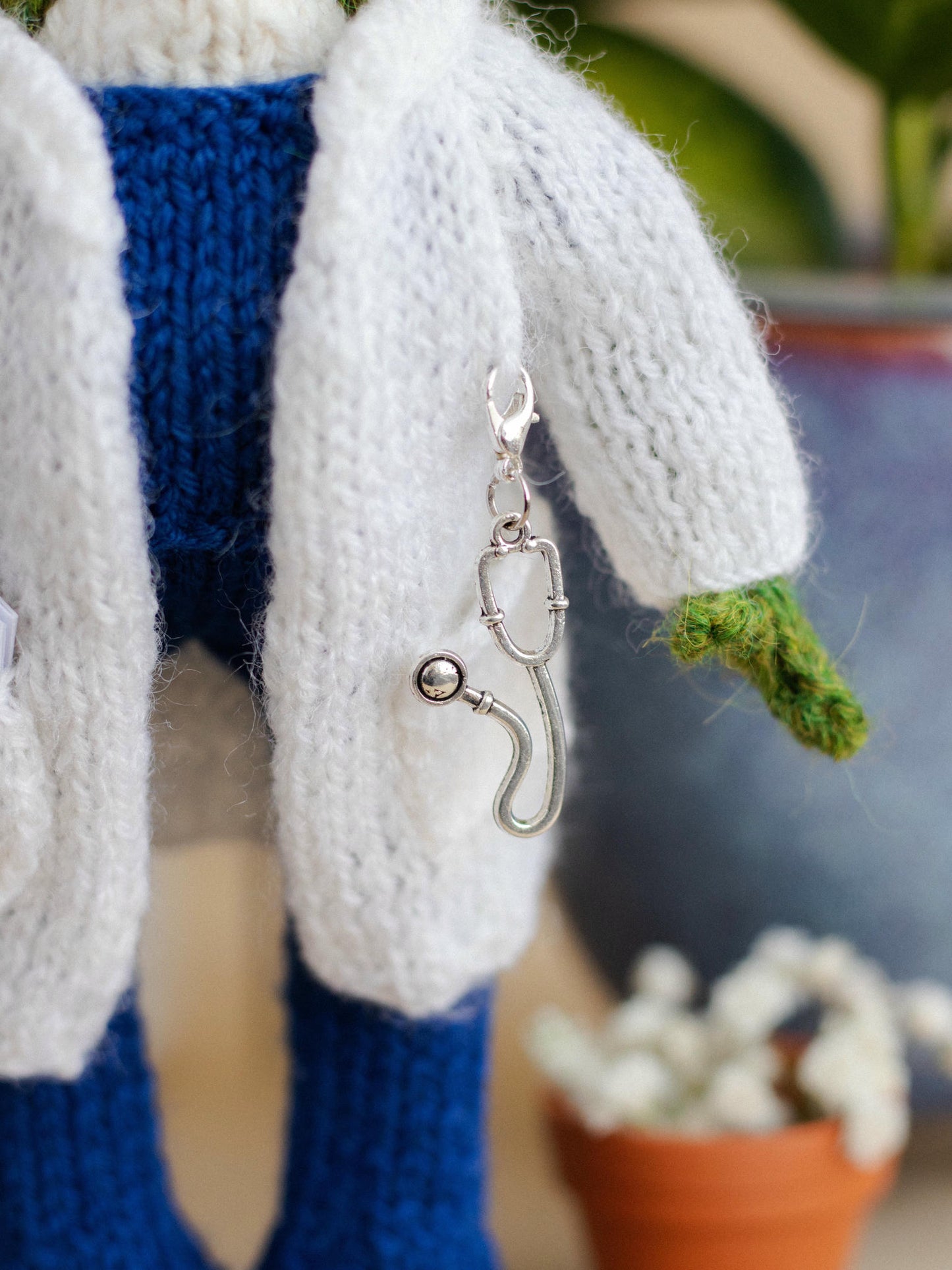 Keychain with a hook attached to a knitted item, with a blurred background